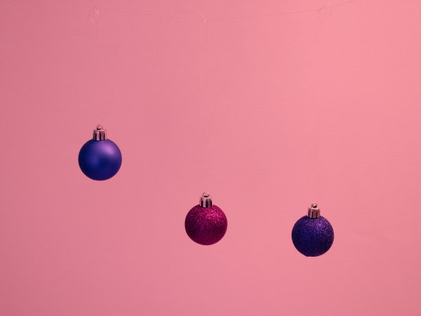 新年的蓝色和红色，发光的装饰，喜庆的球在粉红色的背景。图片下载