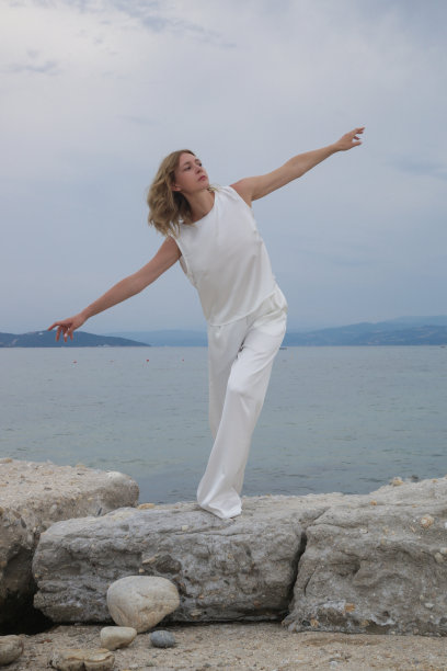 时尚户外肖像的女模特在白色丝绸服装在海滩上图片下载