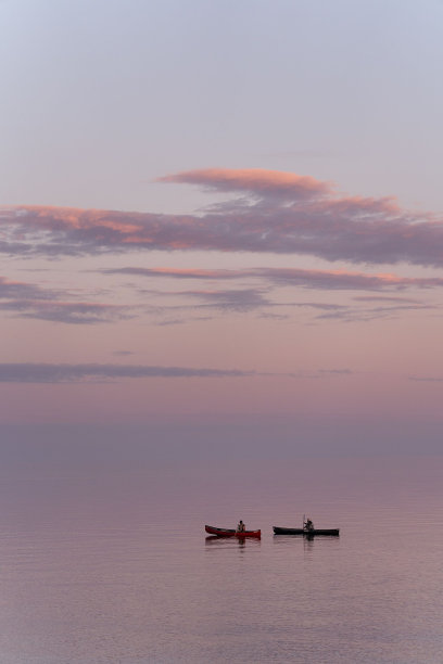 夕阳下美丽的苏必利尔湖上的皮划艇者的垂直照片图片下载