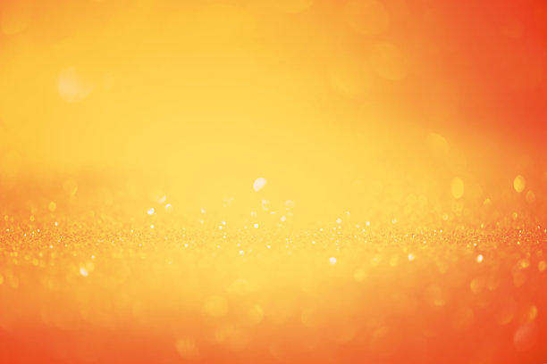 橙色闪光背景离焦和窄焦部分。设计师的材料是闪亮的橙色。图片下载