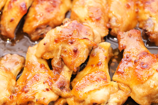 烤鸡翅部分与大蒜在煎锅近食物照片。刚出炉的烤家禽。自制的厨房。在家做饭。图片下载