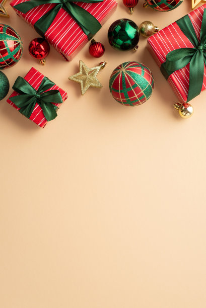 新年的概念。顶视图垂直照片的礼品盒丝带蝴蝶结绿色红色小饰物和金色星星装饰孤立的米色背景与copyspace图片下载