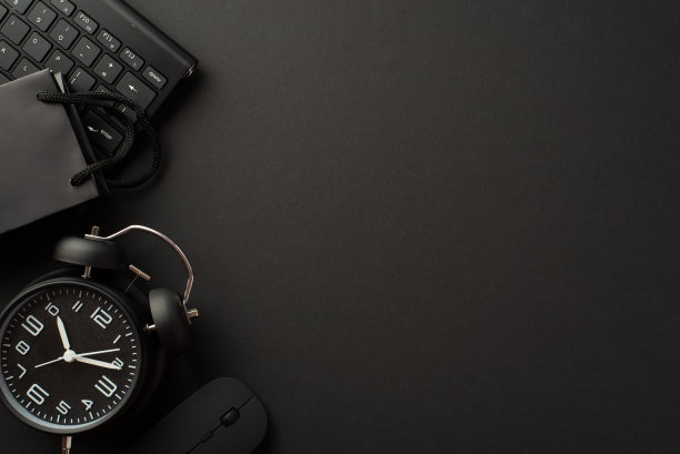 “黑色星期五”的概念。顶视图照片黑色闹钟纸袋电脑鼠标和键盘上孤立的黑色背景与copyspace图片下载