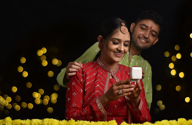 年轻夫妇庆祝排灯节，丈夫给妻子惊喜礼物库存照片图片下载
