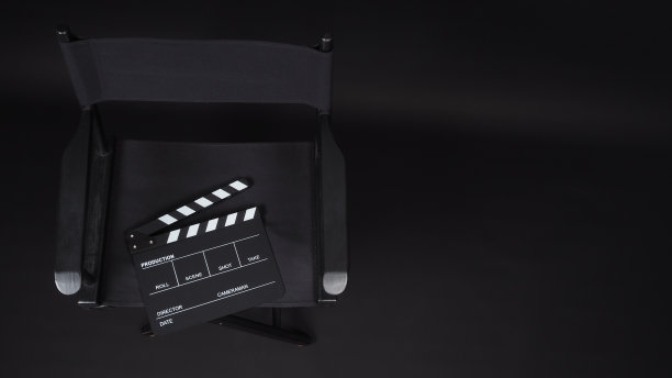 拍板或拍板或电影板与导演椅使用在视频制作，电影，电影行业的黑色背景。图片下载