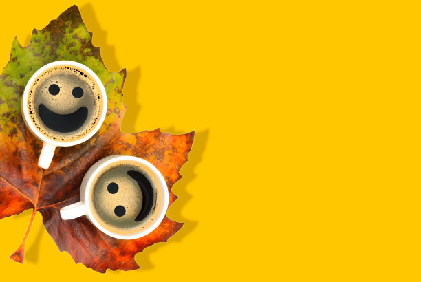 两个咖啡杯放在黄色的枫叶上图片下载