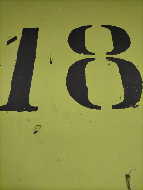 18号，在开心果色的混凝土墙上用黑色画了18号。图片下载
