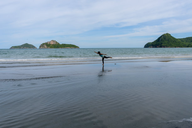 一个女人喜欢在阴天的海滩上做瑜伽图片下载