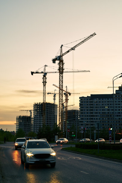 塔吊和建筑工地上的新建筑剪影在黄橙色的天空日落图片下载