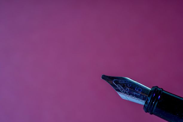 紫色背景下的钢笔特写图片下载