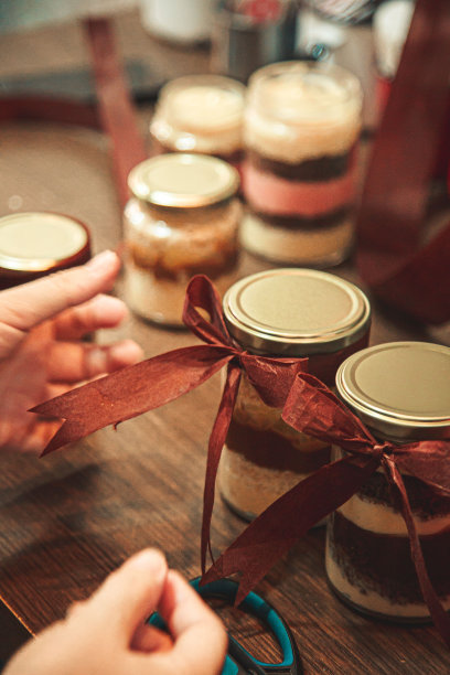 一个女人在融化的糖果罐上系丝带图片下载