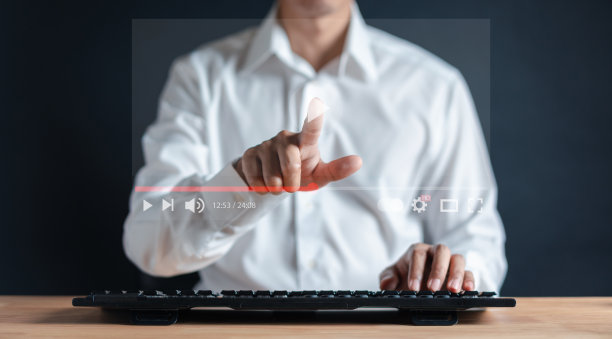 男子使用键盘在虚拟尖叫全息图流媒体在线，在互联网上观看视频，现场音乐会，表演或教程。图片下载