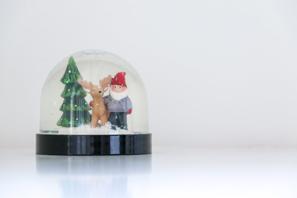 圣诞雪花球上有圣诞老人、他的驯鹿和一棵圣诞树，以白色的雪景为背景，节日装饰装饰，复制空间在右边图片下载