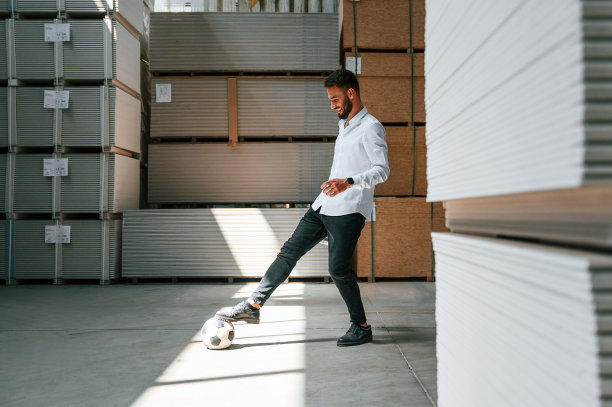 的乐趣。踢足球。仓库工人在仓库里拿着一堆产品图片下载