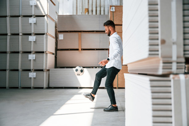 休息一下，踢足球。仓库工人在仓库里拿着一堆产品图片下载