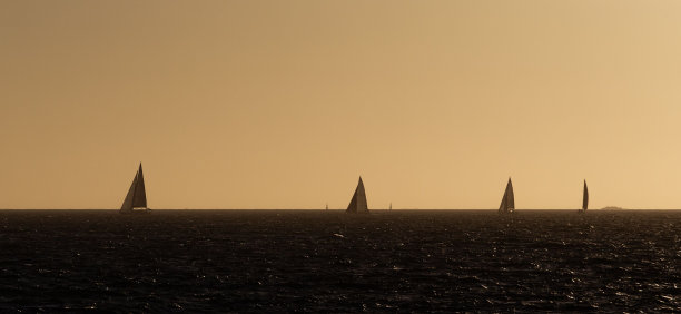 夕阳下海上帆船的美丽照片图片下载