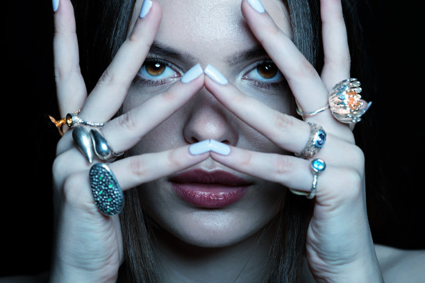 工作室的肖像美丽和性感的女人与花哨的各种戒指在她的手指图片下载