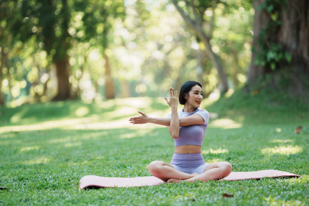 年轻漂亮的亚洲女子在公园里练瑜伽。图片下载