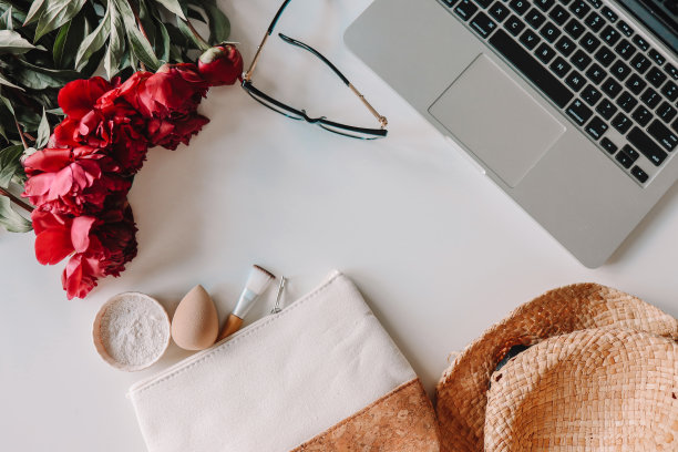 女孩的办公室，笔记本电脑，化妆包，鲜花俯视图图片下载