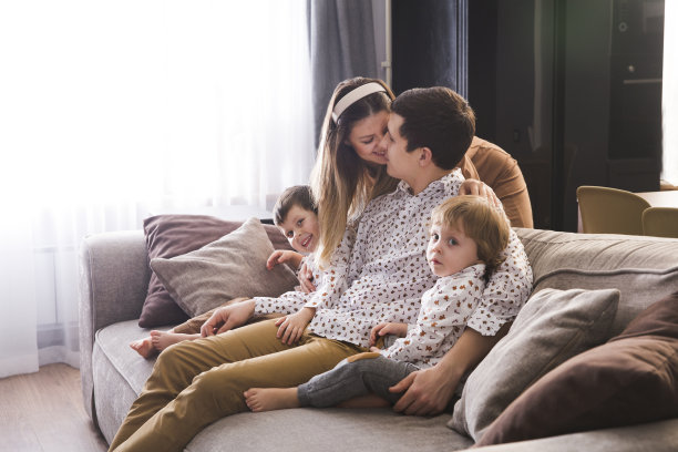 家人在家里共度时光很开心。妈妈，爸爸和两个孩子一起在家里玩，拥抱，玩得很开心图片下载