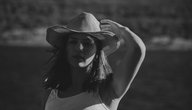 在一个阳光明媚的日子里，戴着帽子的牛仔女孩看着相机图片下载