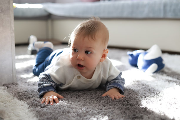 顽皮的婴儿在地板上爬。股票的照片。图片下载