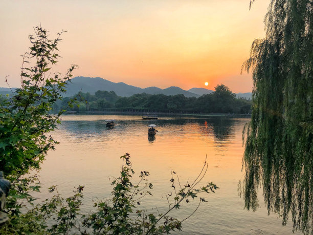景色杭州河和船与山，树木和美丽的日落为背景图片下载