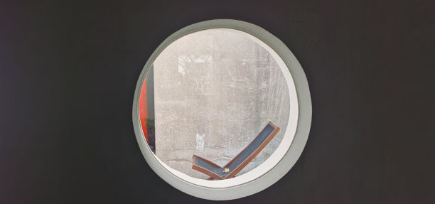 透过墙上的圆形玻璃窗可以看到椅子图片下载