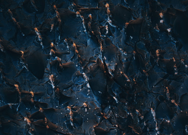岩石纹理。黑暗的石墙。石头的背景。岩石表面具有全息、珍珠般的光泽。墙的抽象。油漆斑点。岩石表面有裂缝。抽象的纹理。图片下载