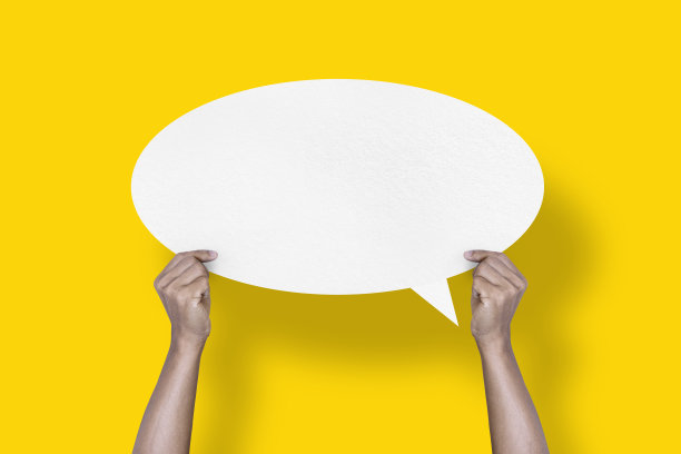 手拿着圆形的白纸气球，黄色背景上孤立的语音气泡图片下载