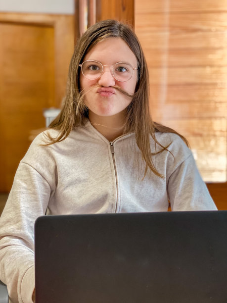 年轻的少女留着自己的胡子，对着镜头做鬼脸图片下载