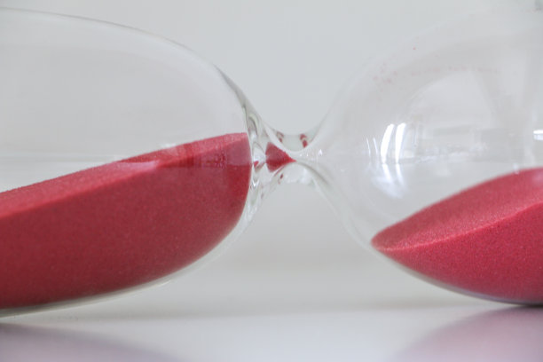 沙漏在它的一面，红色的沙子不再运行时间，意味着时间的暂停，间隔，休息的时间图片下载