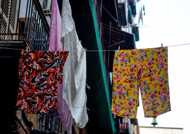 用五颜六色的衣服挂在绳子上的建筑物图片下载