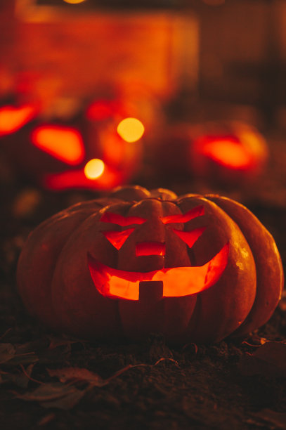美丽的微笑发光橙色滑稽的脸雕刻南瓜万圣节假期在晚上户外图片下载
