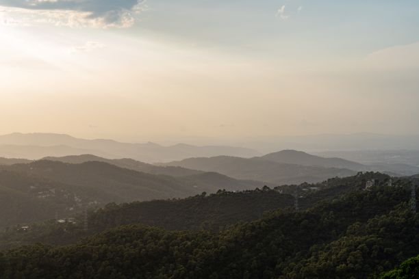 日出时被薄雾覆盖的山轮廓的风景照片图片下载