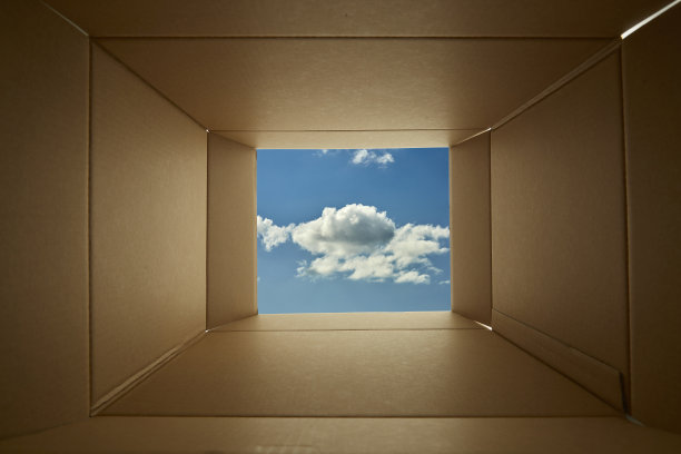 透过纸板箱向蓝色的天空背景看。图片下载