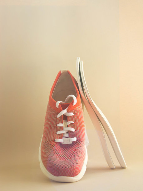 矫形鞋垫与橙色运动鞋。中性的背景。预防足部疾病的概念图片下载