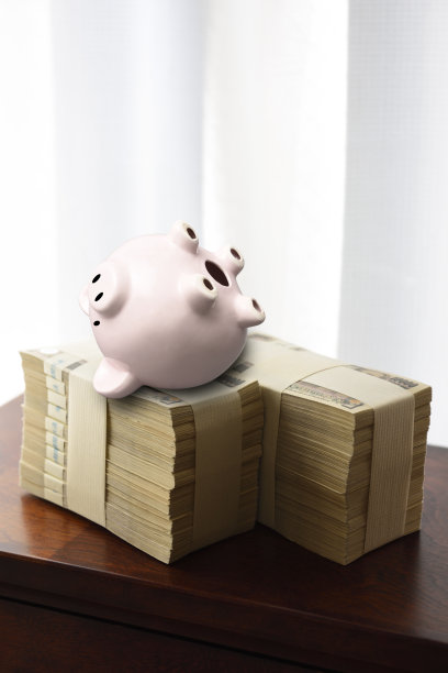 成堆的日本钞票和上下颠倒的储蓄罐图片下载