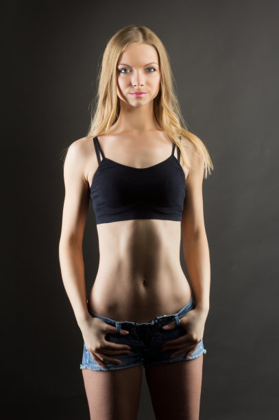 女人运动服。服装模板。运动时尚。健身机构。无法辨认的女运动员苗条的身体在标志模型设计黑色网格胸罩短裤孤立的白色复制空间广告背景。图片下载