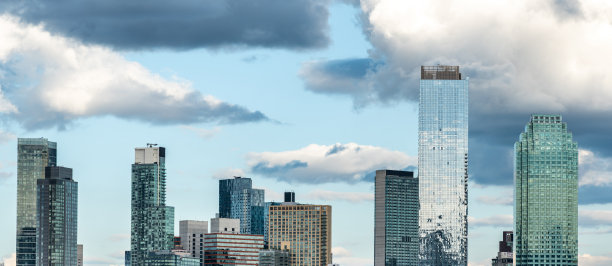 摩天大楼的玻璃塔似乎漂浮在多云的天空中图片下载