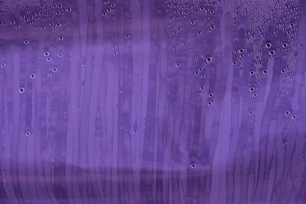 水跑下来。保鲜膜上冷凝水。紫色的颜色。摘要图片下载