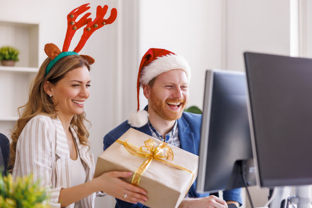 商务同事在办公室庆祝圣诞节的时候有神秘的圣诞老人图片下载