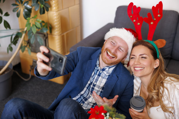 商务人士在办公室庆祝圣诞节时用智能手机自拍图片下载