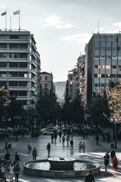 人们在宪法广场上行走，广场上有多层建筑和喷泉图片下载