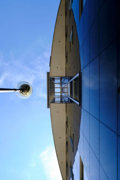 低角度拍摄的城市建筑，在蓝天下，玻璃幕墙和长走廊屋顶图片下载