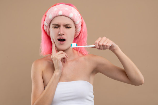 粉红色头发的年轻女孩牙疼，看起来很不高兴图片下载