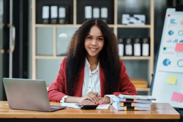 友好的商务女性使用智能手机，脸上带着微笑交谈。快乐的女电话在工作。迷人的民族模特，黑色长发，穿着正式图片下载