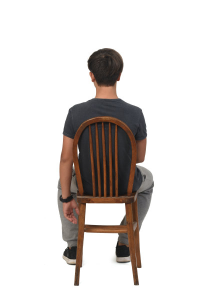 一个十几岁的男孩坐在一张白色背景的椅子上，图片下载