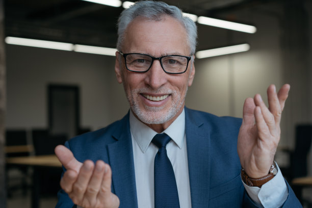 帅气的高级商务教练在视频通话，对着镜头说话，解释什么。网络研讨会，视频会议，在线会议的概念图片下载