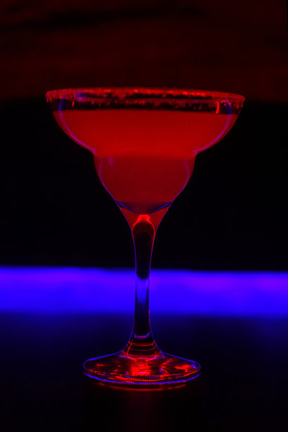 美味的创意明亮的鸡尾酒酒精与吸管是在一个俱乐部或一个照明酒吧的桌子上图片下载